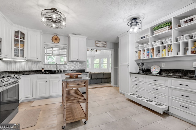 2716 Meadow Ridge Dr NW, Duluth, GA 30096 - kitchen featuring stainless steel range with gas cooktop, white cabinets, open shelves, tasteful backsplash, and a textured ceiling