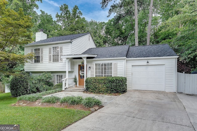 2716 Meadow Ridge Dr NW, Duluth, GA 30096 - tri-level home with concrete driveway, an attached garage, a chimney, and a shingled roof
