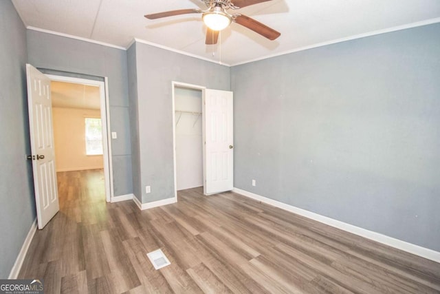 381 Jim Turner Rd, West Point, GA 31833 - unfurnished bedroom with wood finished floors, crown molding, a closet, and a ceiling fan