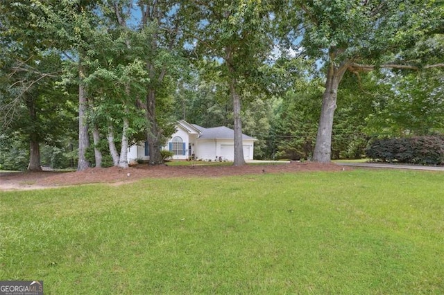 408 Victoria Place Dr, Locust Grove, GA 30248 - view of green lawn with an attached garage and view of scattered trees