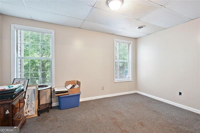 408 Victoria Place Dr, Locust Grove, GA 30248 - empty room featuring dark carpet, a drop ceiling, and plenty of natural light