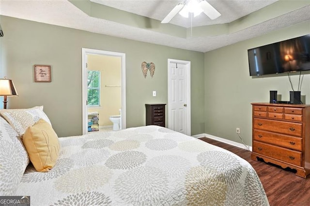 408 Victoria Place Dr, Locust Grove, GA 30248 - bedroom with dark wood-style flooring, a tray ceiling, ensuite bath, and ceiling fan