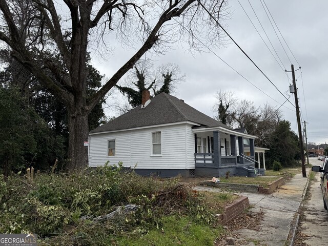 416 Middle St, Macon, GA 31201 - view of side of home with covered porch, a chimney, and roof with shingles