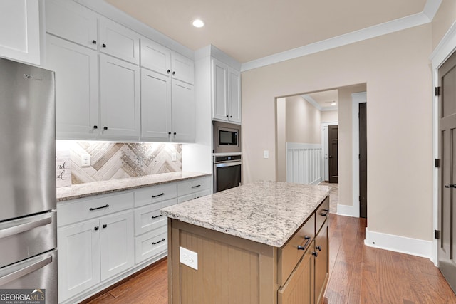 35 Cornish Creek Ln, Covington, GA 30014 - kitchen featuring appliances with stainless steel finishes, ornamental molding, recessed lighting, tasteful backsplash, and a center island