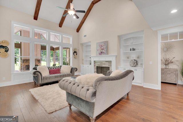35 Cornish Creek Ln, Covington, GA 30014 - living area with high vaulted ceiling, a tile fireplace, a ceiling fan, beamed ceiling, and built in features