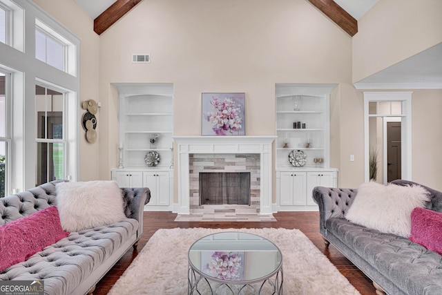 35 Cornish Creek Ln, Covington, GA 30014 - living area with high vaulted ceiling, dark wood finished floors, beamed ceiling, a fireplace, and built in shelves