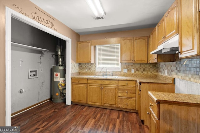 1799 Harmony Rd, Powder Springs, GA 30127 - kitchen with under cabinet range hood, water heater, dark wood finished floors, and backsplash
