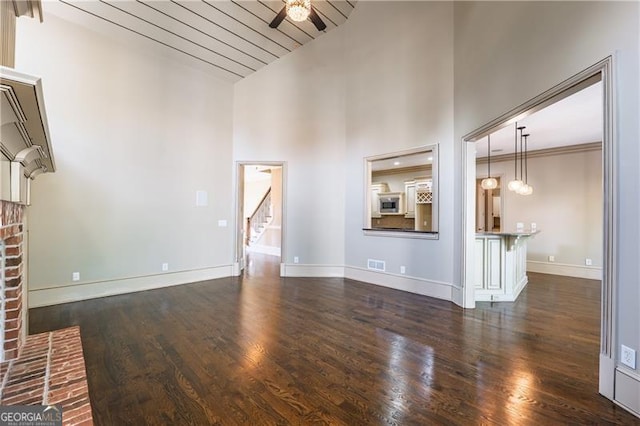 6186 Talmadge Run NW, Acworth, GA 30101 - unfurnished living room featuring ceiling fan, dark wood-type flooring, high vaulted ceiling, and stairway