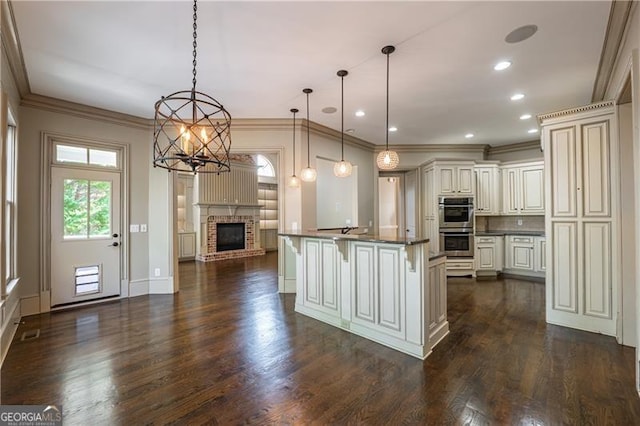 6186 Talmadge Run NW, Acworth, GA 30101 - kitchen with stainless steel double oven, dark countertops, a chandelier, dark wood finished floors, and ornamental molding