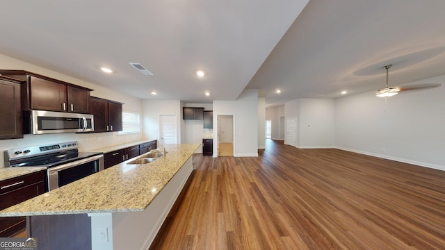458 Southern Oaks Dr, Macon, GA 31216 - kitchen featuring appliances with stainless steel finishes, dark brown cabinets, wood finished floors, a ceiling fan, and a kitchen island with sink