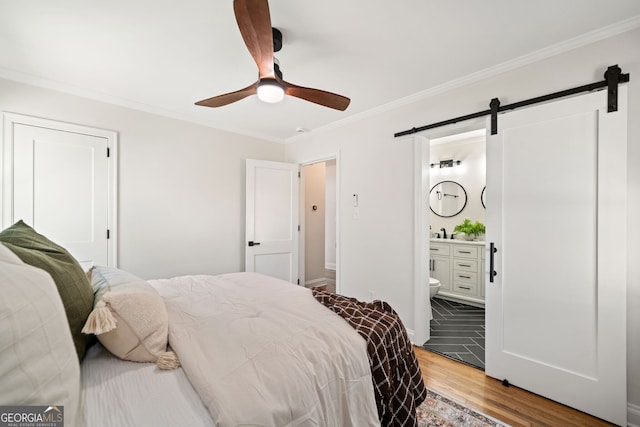 1891 W Forrest Ave, Atlanta, GA 30344 - bedroom featuring a barn door, wood finished floors, ornamental molding, ensuite bath, and ceiling fan