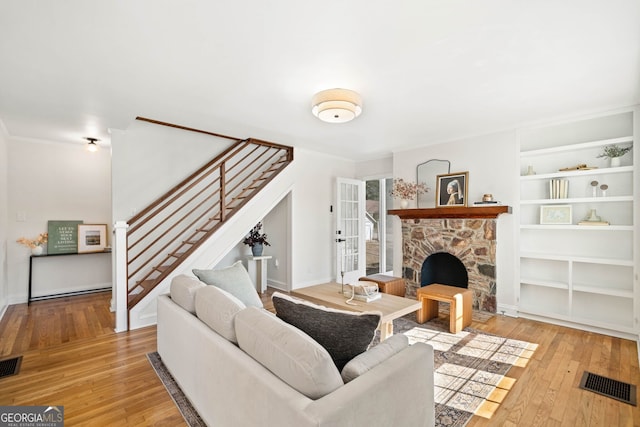 1891 W Forrest Ave, Atlanta, GA 30344 - living area featuring stairway, light wood-style flooring, a stone fireplace, and built in features