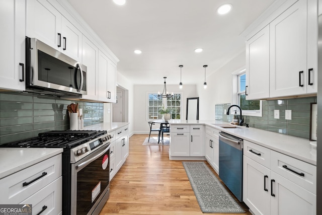 1891 W Forrest Ave, Atlanta, GA 30344 - kitchen featuring stainless steel appliances, a chandelier, light wood-style flooring, white cabinets, and light countertops