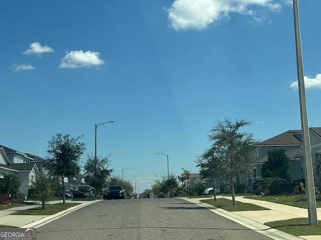 541 Buchannan Dr, Davenport, FL 33837 - view of asphalt street featuring street lighting, sidewalks, curbs, and a residential view
