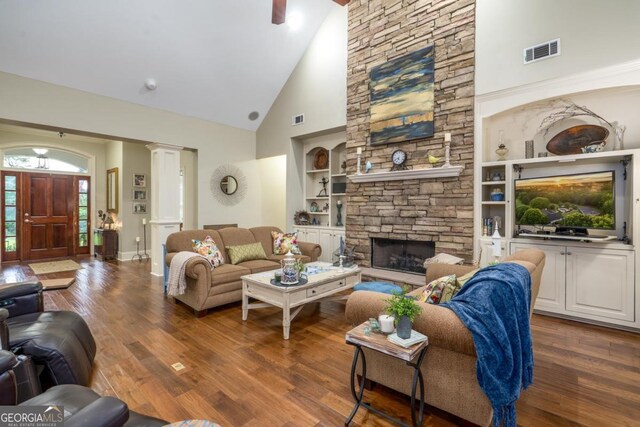 1421 Jack Malcom Rd, Madison, GA 30650 - living room with high vaulted ceiling, built in features, wood finished floors, a stone fireplace, and ornate columns