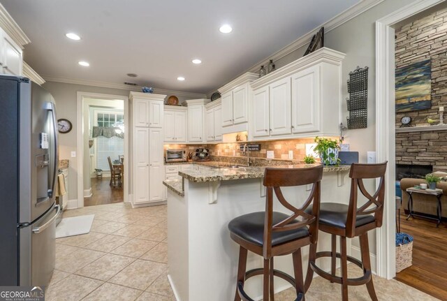 1421 Jack Malcom Rd, Madison, GA 30650 - kitchen with stainless steel refrigerator with ice dispenser, a peninsula, stone countertops, white cabinets, and recessed lighting