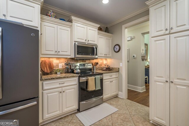 1421 Jack Malcom Rd, Madison, GA 30650 - kitchen with appliances with stainless steel finishes, decorative backsplash, stone countertops, ornamental molding, and light tile patterned floors