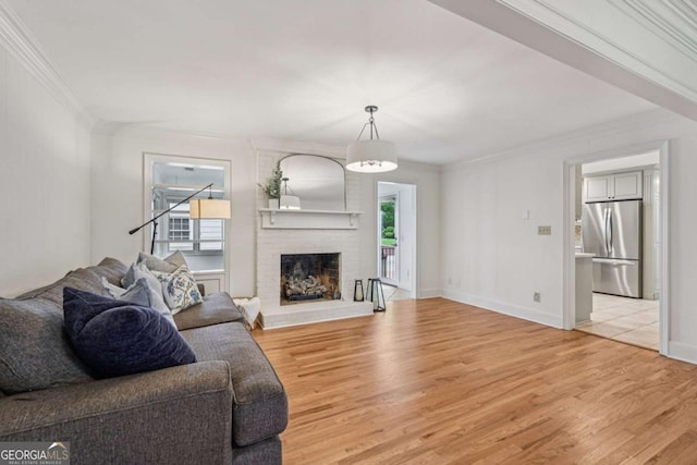 1501 Memory Ln SE, Smyrna, GA 30080 - living area with crown molding, light wood-style floors, and a brick fireplace