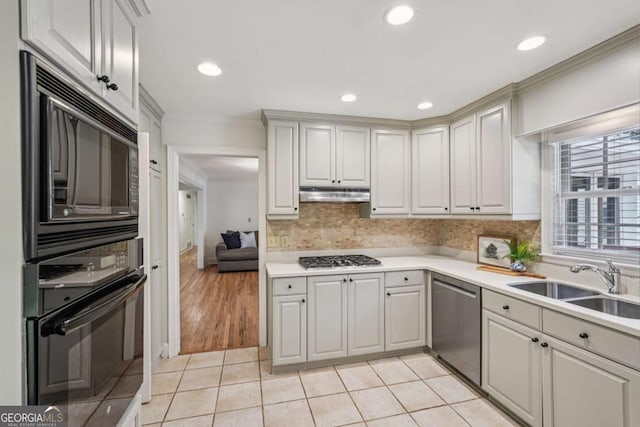 1501 Memory Ln SE, Smyrna, GA 30080 - kitchen with black appliances, under cabinet range hood, crown molding, light countertops, and light tile patterned flooring