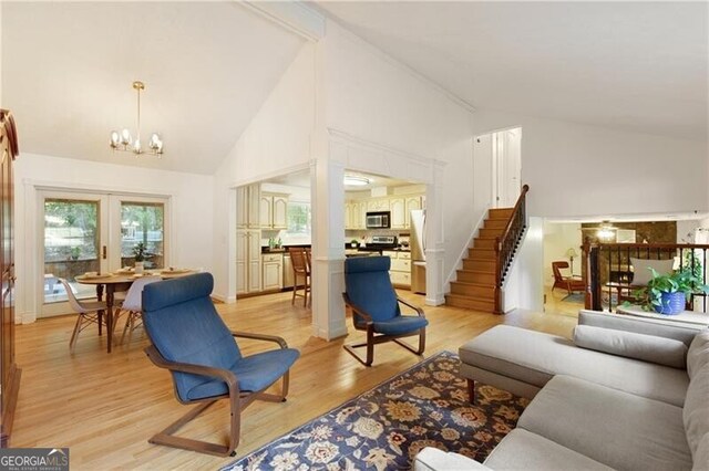 9685 Cone Ct, Roswell, GA 30075 - living area featuring high vaulted ceiling, a chandelier, light wood-style floors, and stairway