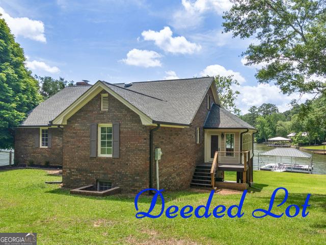 210 Roberts Point Rd, Jackson, GA 30233 - view of front of house with brick siding, a front lawn, and a shingled roof