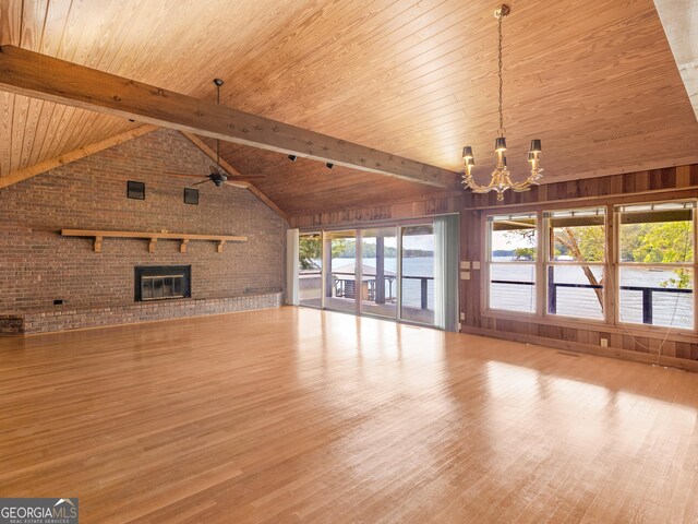 210 Roberts Point Rd, Jackson, GA 30233 - unfurnished living room with a chandelier, wood finished floors, brick wall, a wooden ceiling with exposed beams, and plenty of natural light