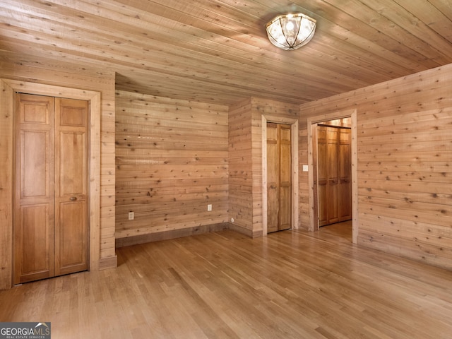 210 Roberts Point Rd, Jackson, GA 30233 - unfurnished bedroom featuring light wood-style flooring, wooden walls, wood ceiling, and two closets