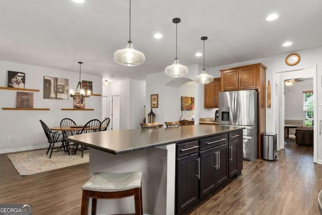7430 Ramsgate Ct, Cumming, GA 30040 - kitchen with stainless steel fridge, dark countertops, dark wood finished floors, a kitchen island, and recessed lighting
