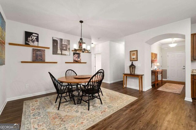 7430 Ramsgate Ct, Cumming, GA 30040 - dining room with arched walkways, dark wood-style flooring, and a chandelier