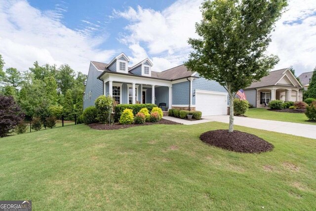 7430 Ramsgate Ct, Cumming, GA 30040 - new england style home featuring concrete driveway, a porch, a front yard, a garage, and stone siding