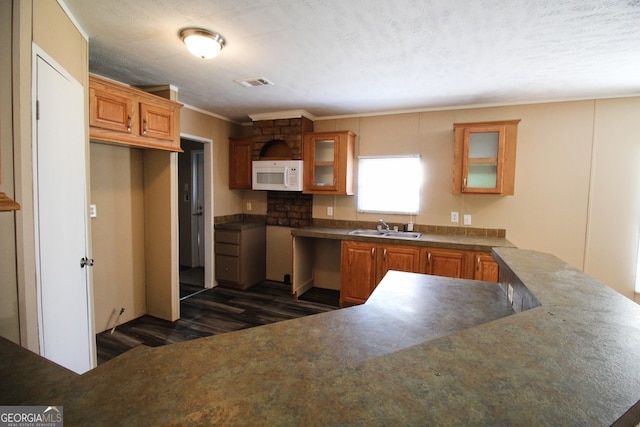 447 Smith Rd, Defuniak Springs, FL 32433 - kitchen featuring white microwave, dark wood-type flooring, glass insert cabinets, brown cabinetry, and crown molding