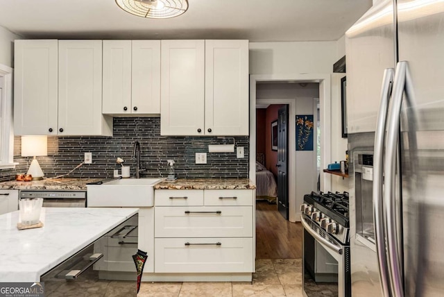 2468 Fallview Ter, Atlanta, GA 30344 - kitchen with stainless steel appliances, white cabinets, decorative backsplash, and light stone countertops