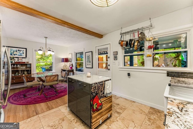 2468 Fallview Ter, Atlanta, GA 30344 - kitchen featuring a chandelier, beam ceiling, light stone countertops, and hanging light fixtures