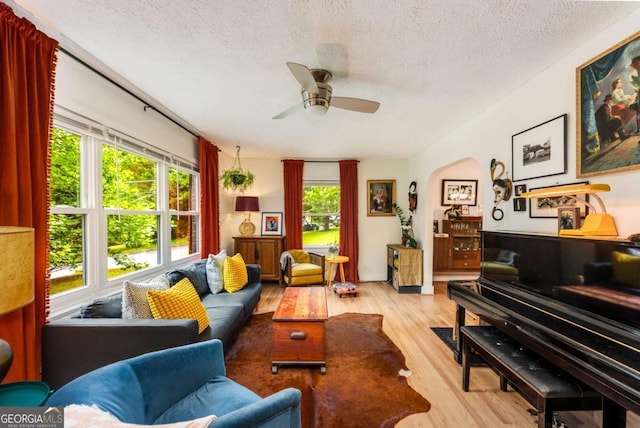 2468 Fallview Ter, Atlanta, GA 30344 - living area featuring a textured ceiling, wood finished floors, a ceiling fan, and arched walkways