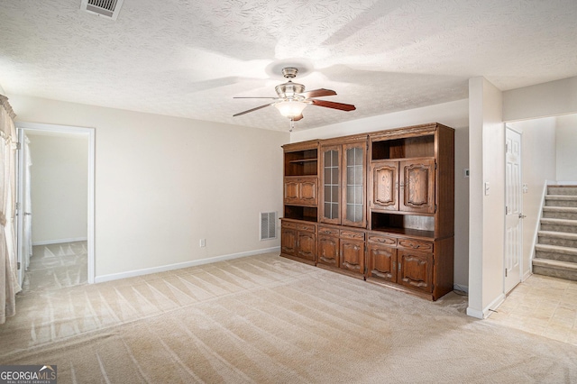 40 Browning Dr, Covington, GA 30016 - unfurnished living room with stairway, a ceiling fan, light carpet, and a textured ceiling