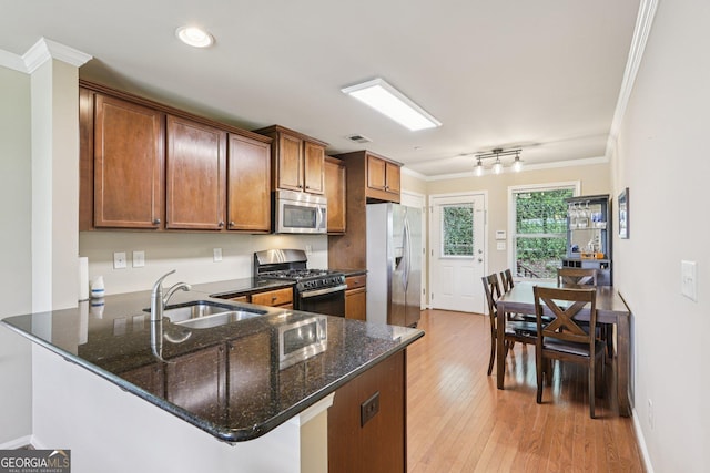 532 Lemon St NE, Marietta, GA 30060 - kitchen featuring appliances with stainless steel finishes, ornamental molding, dark stone counters, a peninsula, and brown cabinets