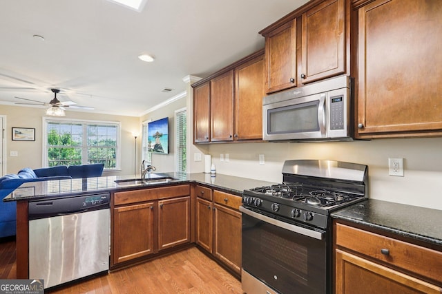 532 Lemon St NE, Marietta, GA 30060 - kitchen featuring stainless steel appliances, a peninsula, light wood-style flooring, a ceiling fan, and crown molding