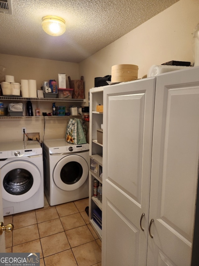 115 Settlers Trl, Warner Robins, GA 31088 - laundry room featuring washer and dryer, a textured ceiling, and light tile patterned flooring