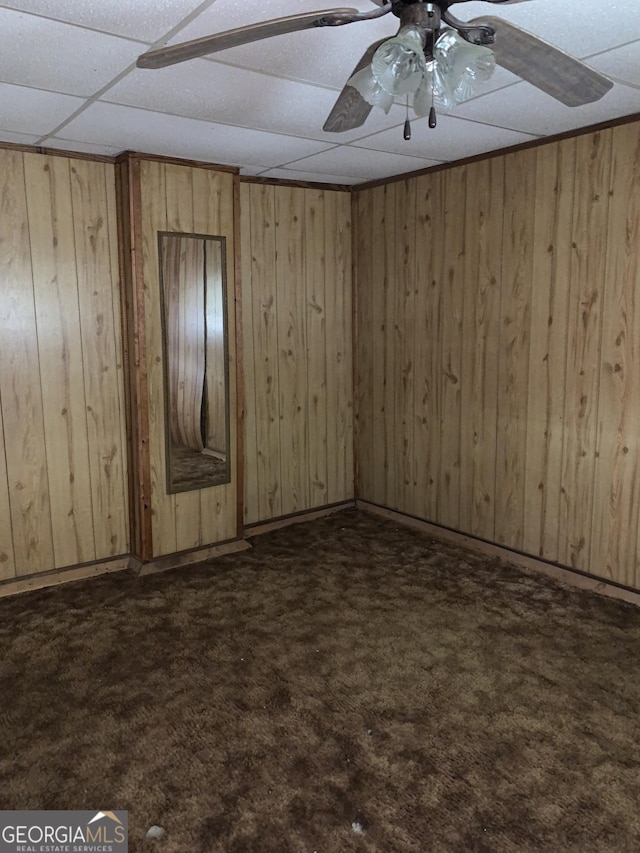 2712 Maple Rd SE, Rome, GA 30161 - empty room featuring dark colored carpet, wooden walls, and a drop ceiling
