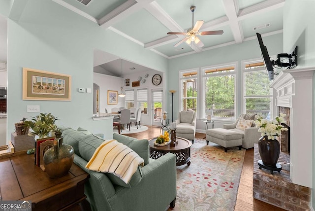 6460 Valley Crossing Way, Cumming, GA 30028 - living area with coffered ceiling, a ceiling fan, wood finished floors, beamed ceiling, and a fireplace with raised hearth