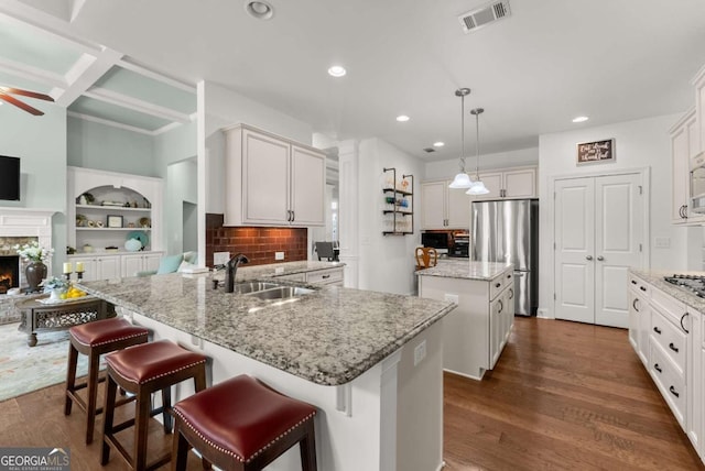 6460 Valley Crossing Way, Cumming, GA 30028 - kitchen featuring stainless steel appliances, a kitchen island, recessed lighting, light stone counters, and dark wood-style flooring