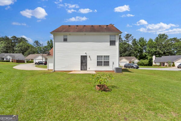 7770 Hana Ct, Jonesboro, GA 30236 - back of property with a lawn and concrete driveway
