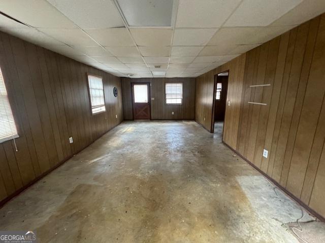 3415 Spring Valley Blvd, South Fulton, GA 30349 - spare room featuring unfinished concrete flooring, wooden walls, and a paneled ceiling