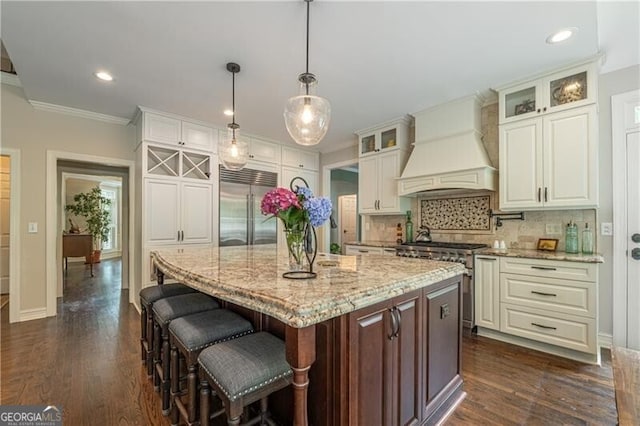 660 Glendalough Ct, Alpharetta, GA 30004 - kitchen featuring premium appliances, premium range hood, dark wood finished floors, a kitchen island, and light stone counters