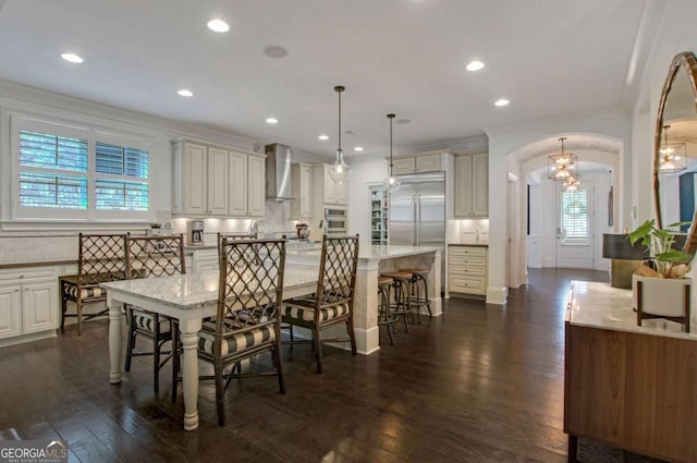3467 Brookleigh Ln NE, Atlanta, GA 30319 - dining space featuring arched walkways, a chandelier, ornamental molding, dark wood-style floors, and recessed lighting