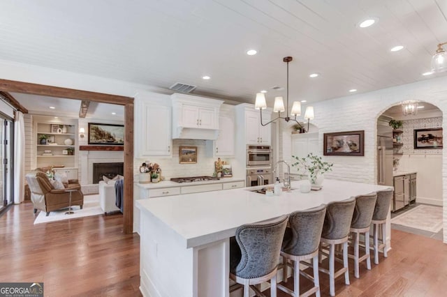 120 Slate Dr, Buford, GA 30518 - kitchen with stainless steel appliances, white cabinets, light countertops, light wood-style floors, and recessed lighting