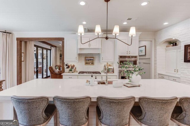 120 Slate Dr, Buford, GA 30518 - kitchen featuring stainless steel appliances, white cabinets, a large island with sink, light countertops, and recessed lighting