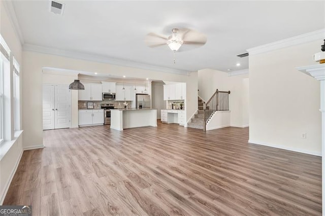 3390 Meadow Grass Dr, Dacula, GA 30019 - unfurnished living room with ceiling fan, crown molding, light wood finished floors, stairway, and recessed lighting