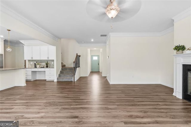 3390 Meadow Grass Dr, Dacula, GA 30019 - unfurnished living room featuring wood finished floors, ornamental molding, stairway, a fireplace, and ceiling fan