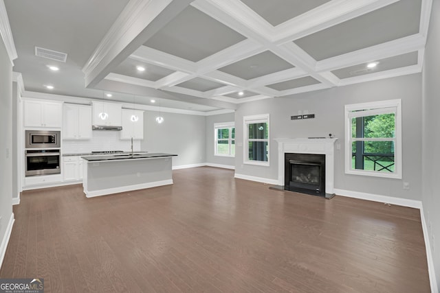 7043 Lancaster Xing, Flowery Branch, GA 30542 - unfurnished living room featuring dark wood finished floors, a fireplace with raised hearth, recessed lighting, beamed ceiling, and crown molding